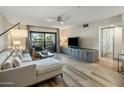 Bright living room featuring hardwood floors, a ceiling fan, and sliding door access to the patio at 5104 N 32Nd St # 105, Phoenix, AZ 85018