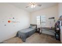 Cozy bedroom featuring neutral carpet, a single bed, and a window offering plenty of natural light at 697 E Ruby Dr, Casa Grande, AZ 85122