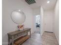 Inviting entryway featuring light gray wood floors, a round decorative mirror, and a console table at 697 E Ruby Dr, Casa Grande, AZ 85122