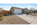 Angle view of home with large two car garage, desert landscaping and walkway to covered entry at 697 E Ruby Dr, Casa Grande, AZ 85122
