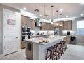 Modern kitchen with stainless steel appliances, granite countertops, island with seating, and stylish pendant lighting at 6983 W Andrea Dr, Peoria, AZ 85383