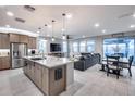 Open-concept kitchen, dining, and living area with tile flooring, large windows, and stylish furnishings at 6983 W Andrea Dr, Peoria, AZ 85383