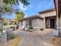 Inviting front patio with cozy seating and a decorative paver walkway at 8654 W Melinda Ln, Peoria, AZ 85382