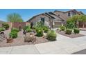 Attractive single-story home with a desert landscape, stone mulch, and a variety of cactus and shrubbery at 12062 W Duane Ln, Peoria, AZ 85383