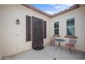 Inviting front porch with an elegant dark metal front door and an outdoor seating area at 19351 E Apricot Ln, Queen Creek, AZ 85142