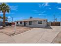 Charming single-story home featuring a gray exterior, palm tree, and expansive front yard at 3212 N 49Th Ln, Phoenix, AZ 85031