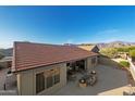 Backyard view showcasing a spacious concrete patio with mountain views, a seating area, and fire pits at 7145 E Cuernavaco Way, Gold Canyon, AZ 85118