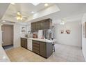 Bright kitchen features tile flooring, skylights, ceiling fan, and an island with seating at 11113 W Cameo Dr, Sun City, AZ 85351