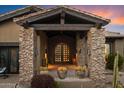 Charming front entrance with stone columns, dark wood accents and desert landscaping at 11240 E Apache Vistas Dr, Scottsdale, AZ 85262