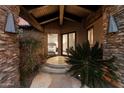 Exterior view of a primary bedroom through the house's stone framed entryway at 11240 E Apache Vistas Dr, Scottsdale, AZ 85262