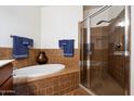 Well-maintained bathroom featuring tiled walls, a soaking tub, and a glass-enclosed shower at 11640 N Tatum Blvd # 3091, Phoenix, AZ 85028