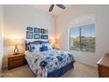 Bright bedroom with a large window, ceiling fan and a blue and white patterned comforter at 11640 N Tatum Blvd # 3091, Phoenix, AZ 85028