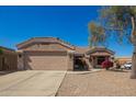 Charming single-story home boasts a well-maintained front yard, two-car garage, and a welcoming entrance at 14514 N 128Th Dr, El Mirage, AZ 85335