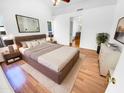 Spacious main bedroom featuring a large bed, hardwood floors, and ensuite bath access at 14950 W Rockrose Way, Surprise, AZ 85374