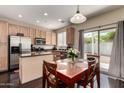 Eat-in kitchen includes stainless steel appliances, dark countertops, and wood dining set at 15054 N 173Rd Dr, Surprise, AZ 85388