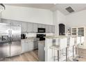 Well-lit kitchen featuring stainless steel appliances, gray cabinets, and a breakfast bar with seating at 17290 N 170Th Ln, Surprise, AZ 85374