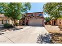 Inviting two-story home with a well-maintained front yard, mature trees, and a two-car garage at 1753 E Maddison Cir, San Tan Valley, AZ 85140