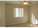 Cozy bedroom with natural light filtering through a window, complemented by a ceiling fan at 2324 W Darrel Rd, Phoenix, AZ 85041