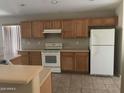 Functional kitchen featuring wood cabinetry, essential appliances, and neutral countertops at 2324 W Darrel Rd, Phoenix, AZ 85041