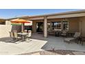 Inviting covered patio with outdoor seating, an orange umbrella, and a grill for entertaining at 24816 S Golfview Dr # 46, Sun Lakes, AZ 85248