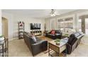 Cozy living room with plush leather seating, neutral walls, plantation shutters, and a ceiling fan at 24816 S Golfview Dr # 46, Sun Lakes, AZ 85248