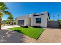 Contemporary home with a black garage door, artificial turf, and desert landscaping at 2927 E Osborn Rd, Phoenix, AZ 85016