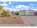 Well-maintained house with a three-car garage and desert landscaping at 3125 W Desert Ln, Laveen, AZ 85339