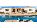 View of a refreshing backyard pool and outdoor lounge area with a covered patio for entertaining at 3125 W Desert Ln, Laveen, AZ 85339