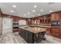 Gourmet kitchen featuring a large island with granite countertops, custom cabinetry, and stainless steel appliances at 3413 E Equestrian Trl, Phoenix, AZ 85044