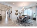 Elegant dining room with modern chandelier, large window with views, and decorative wall art at 4949 W Walatowa St, Laveen, AZ 85339
