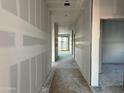 Spacious hallway with drywall installed, leading to various rooms and an outdoor view at 5634 W Olney Ave, Laveen, AZ 85339