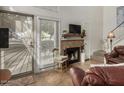 Cozy living room features a brick fireplace, tile flooring, and natural light from the large window at 602 N May St # 65, Mesa, AZ 85201