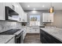 Bright kitchen featuring white cabinets, marble countertops, stainless steel appliances, and a farmhouse sink at 8712 W Sequoia Dr, Peoria, AZ 85382