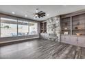 Spacious living room with built-in shelving, a fireplace, hardwood floors, and access to an outdoor area at 8712 W Sequoia Dr, Peoria, AZ 85382