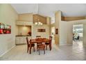 Inviting dining area with a wet bar, pendant lighting, and view to outside patio at 9717 W Marco Polo Rd, Peoria, AZ 85382