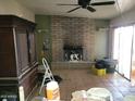 Spacious living room with brick fireplace needs decluttering and a refresh to highlight its potential at 14627 N 33Rd Ave, Phoenix, AZ 85053