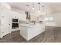 A modern kitchen features a large center island, stainless steel appliances, and plenty of white cabinetry at 20255 W Monterey Way, Buckeye, AZ 85396