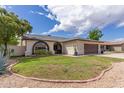 Well-kept single-story home features a lush green lawn and unique arched windows at 2109 W El Alba Way, Chandler, AZ 85224