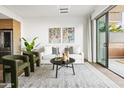 A modern living room with a neutral color scheme, contemporary art, and a glass door to the patio at 2300 E Campbell Ave # 106, Phoenix, AZ 85016