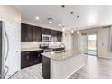 Modern kitchen featuring a granite island, stainless steel appliances, and dark wood cabinetry at 34710 N 27Th Ave, Phoenix, AZ 85086
