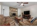 Inviting living room with stone fireplace, ceiling fan, and plank flooring at 3526 N 85Th St, Scottsdale, AZ 85251