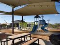 Community playground featuring slides, covered seating areas, and ample space for recreational activities at 37049 N Lokai Dr, San Tan Valley, AZ 85140