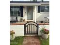 Charming home featuring a lovely entrance with a quaint black gate and potted flowers at 4314 E Montecito Ave, Phoenix, AZ 85018