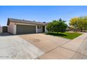 Well maintained one story home featuring manicured lawn, mature trees, and convenient two-car garage at 4421 S Terrace Rd, Tempe, AZ 85282