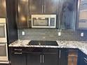 Modern kitchen featuring stainless steel microwave, dark cabinetry, and granite countertops at 6506 S 50Th Ln, Laveen, AZ 85339
