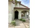 Inviting front entrance with a dark wood door, arched detailing, and desert landscaping at 7336 E Overlook Dr, Scottsdale, AZ 85255
