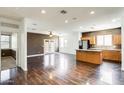 Open concept floorplan with hardwood floors connecting the living room, dining area, and kitchen at 809 S 120Th Ave, Avondale, AZ 85323