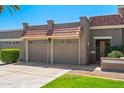 Close up of a lovely single-story home featuring an attached two-car garage with tile roofing, and manicured landscaping at 9847 E Michigan Ave, Sun Lakes, AZ 85248