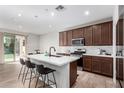 Bright kitchen features a central island with seating and stainless steel appliances at 10983 W Mckinley St, Avondale, AZ 85323