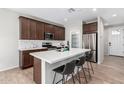 Well-lit kitchen features stainless steel appliances, a spacious island, and dark wood cabinetry at 10983 W Mckinley St, Avondale, AZ 85323
